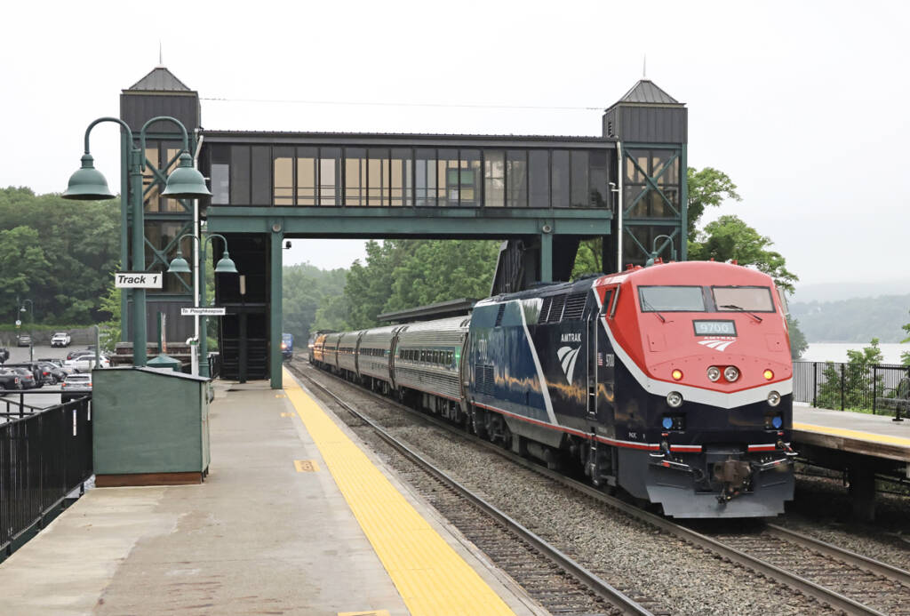 Blue and red converted locomotive on end of passenger train.