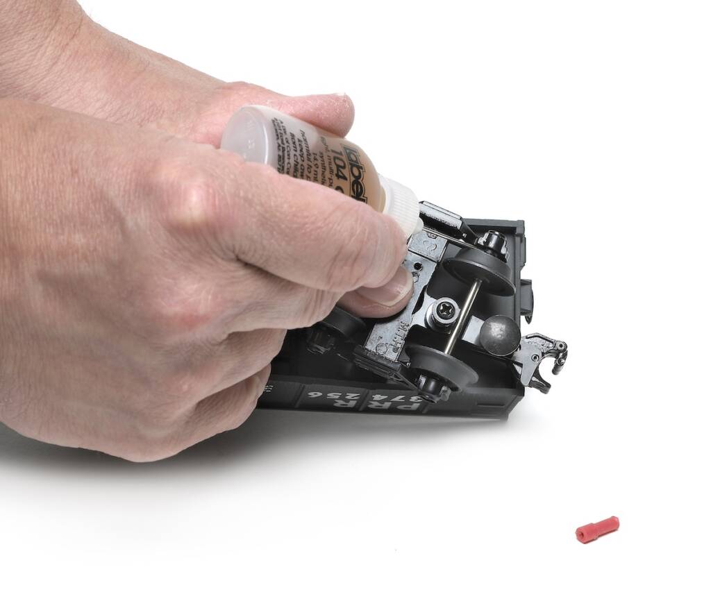 hand oiling axle on model train