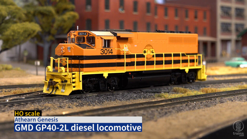Title screen from product review video with HO scale diesel painted orange, black, and yellow on scenicked layout with title bar in lower left corner.