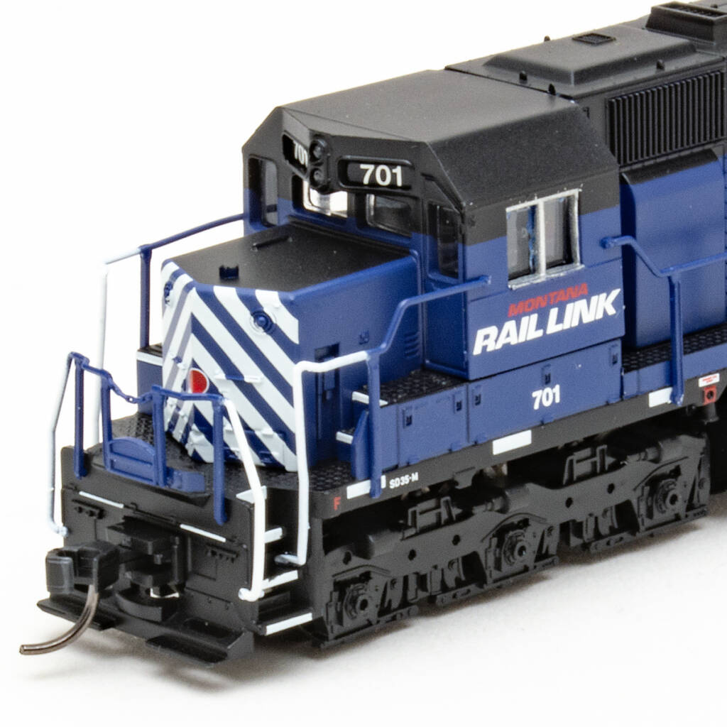Color photo showing cab and short hood of N scale diesel painted blue and black on white background.