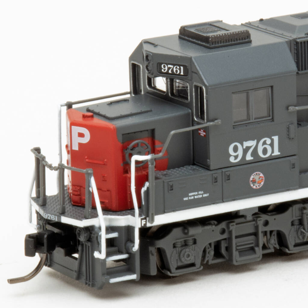 Color photo showing nose of N scale diesel painted scarlet and gray on white background.