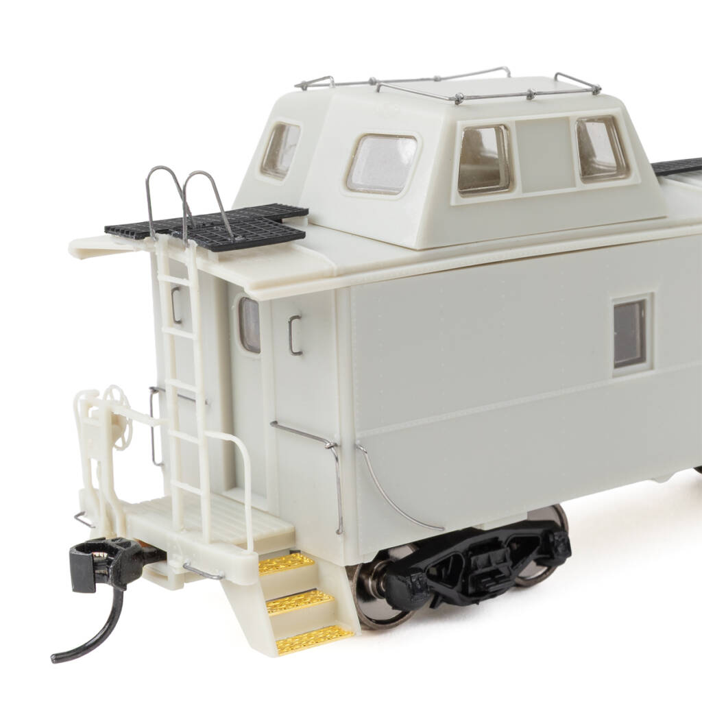 Color photo of HO scale caboose molded in gray plastic with formed wire and etched-brass detail parts.