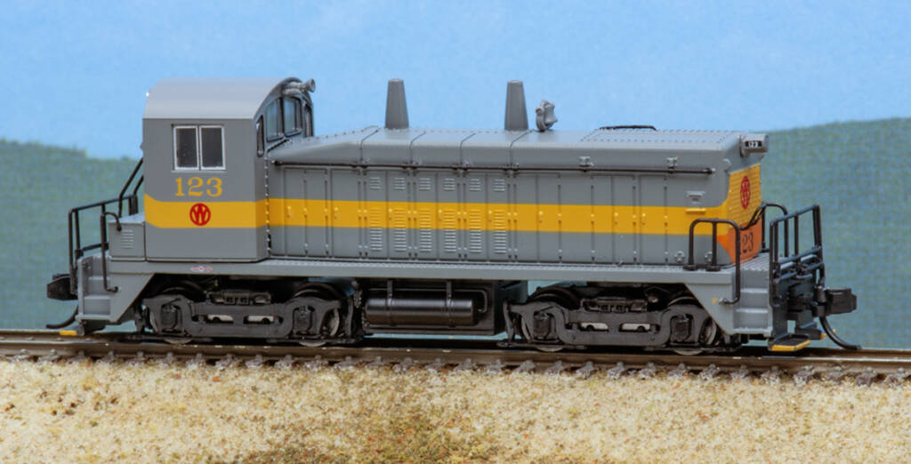 Color photo of N scale end-cab switcher painted gray with yellow stripe.