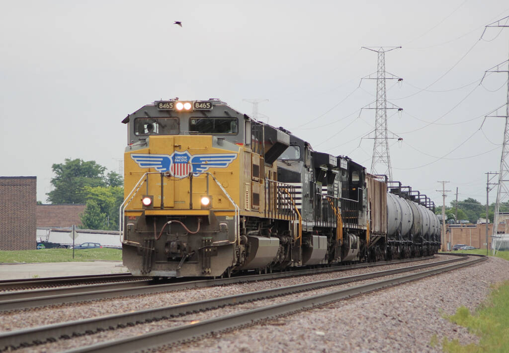 Yellow and black locomotives leading train of tank cars