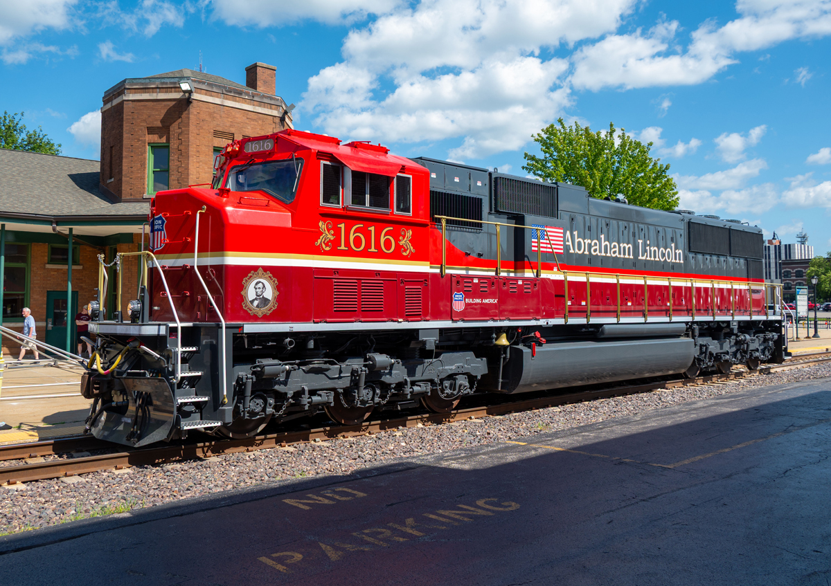 Side view of red, maroon, and gray locomotive