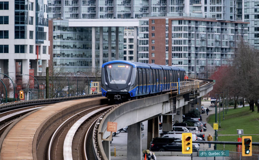 Blue and black transit train on elevated right-of-way