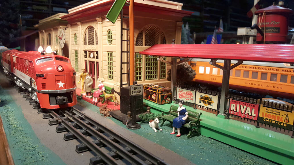 Two toy passenger trains on a model railroad layout