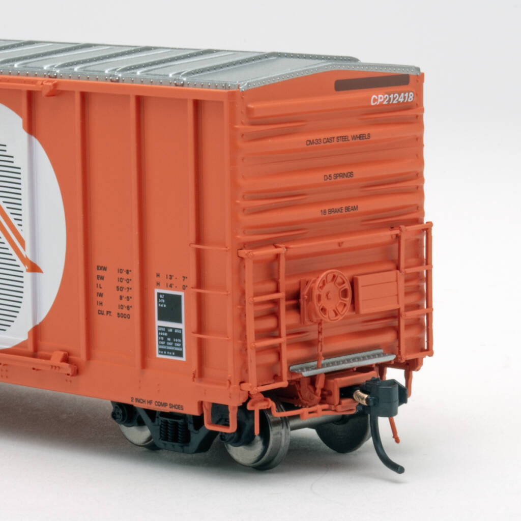 Color photo showing B end of HO scale boxcar painted orange with black, white, and orange graphics on white background
