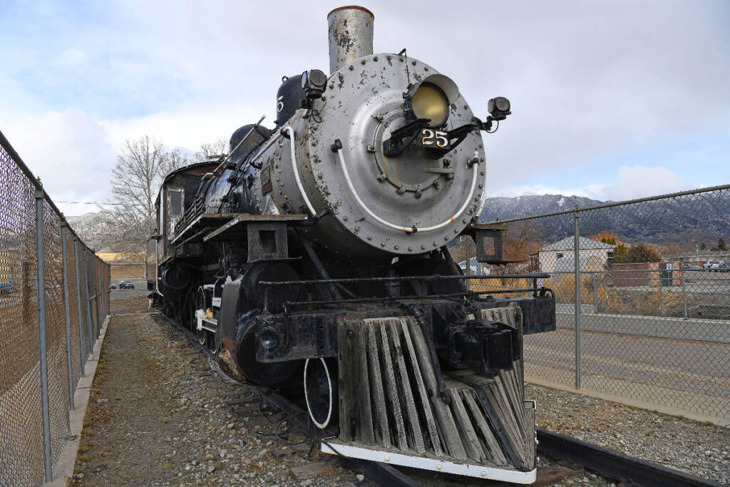 Black and silver steam locomotive inside fence. Butte restores NP No. 25
