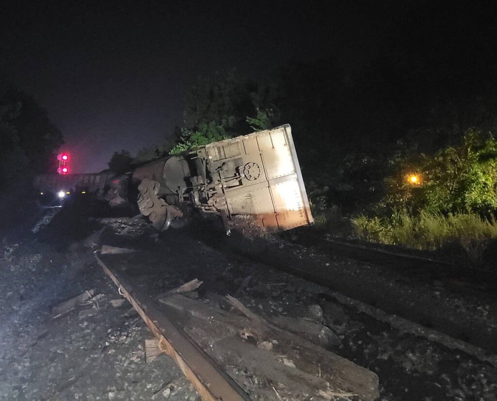 Derailed coal hopper cars at night