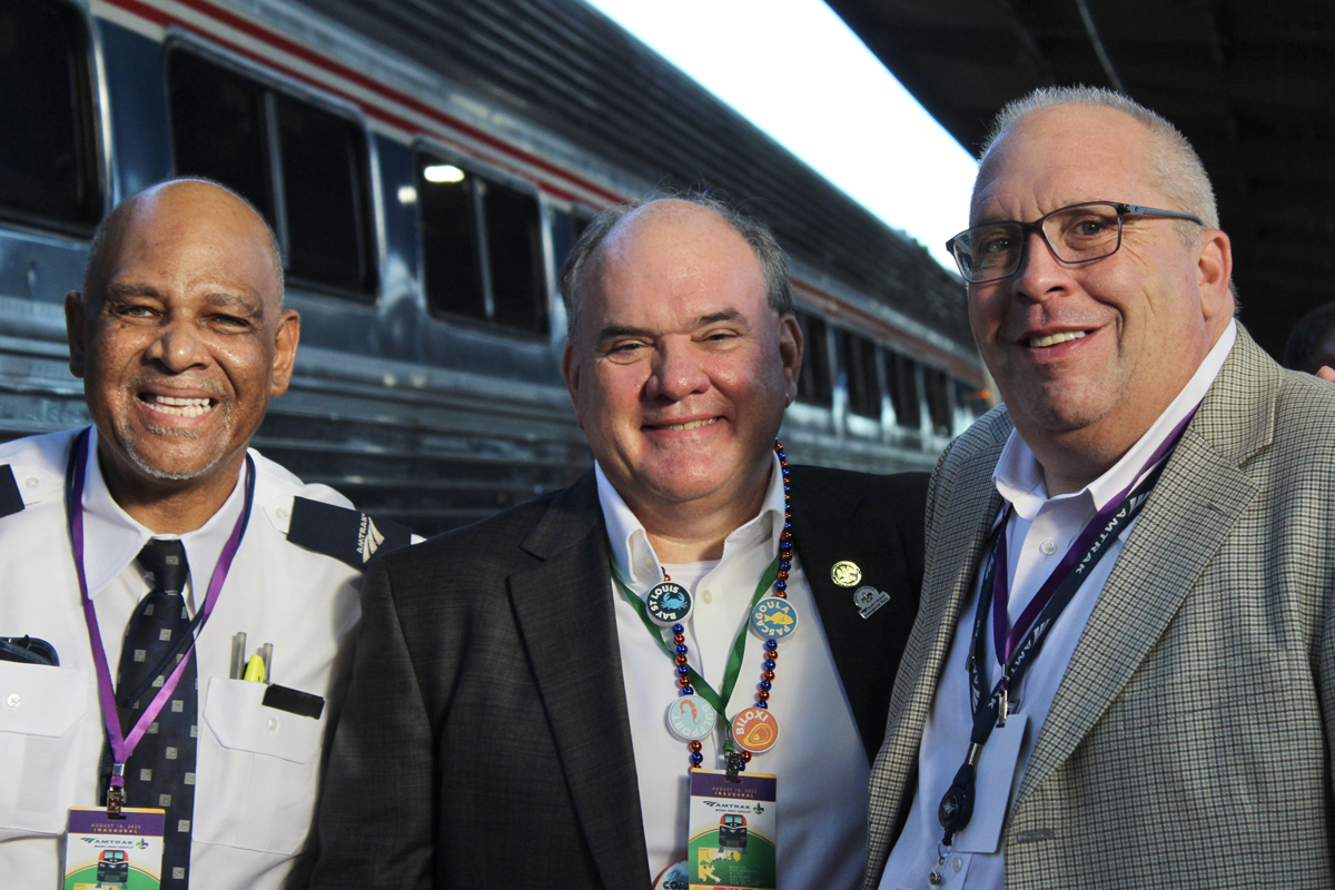 Three men on station platform. Aug. 16, 2025