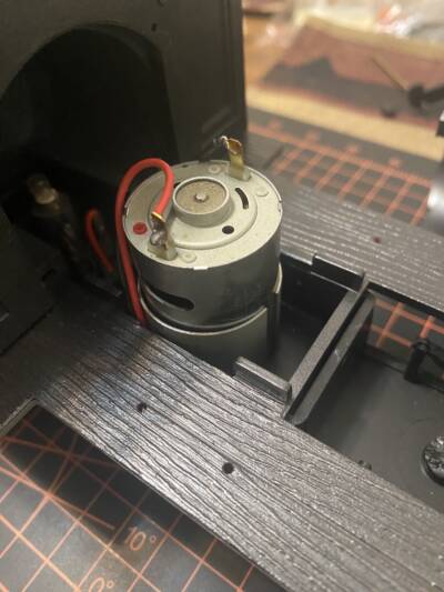 Motor sitting inside the frame of a large scale steam locomotive