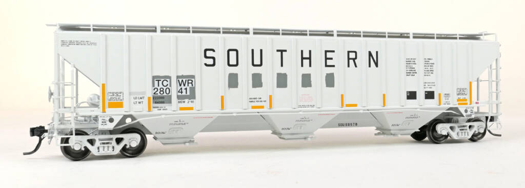 Color photo of HO scale three-bay covered hopper painted gray with black, red, and yellow graphics on white background