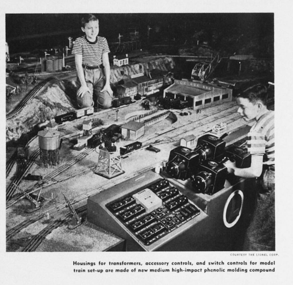 black-and-white photograph of model train layout with two boys