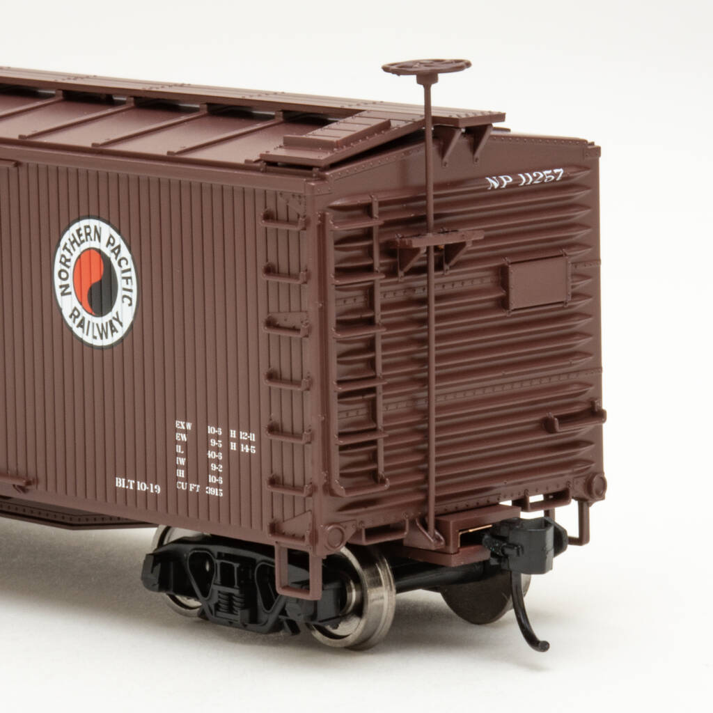 Color photo showing B end of of brown HO scale boxcar with red, white, and black graphics on white background