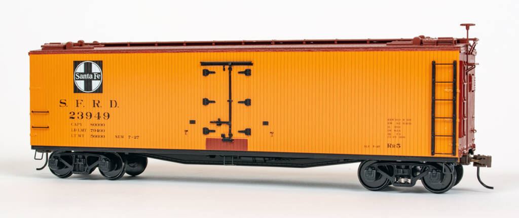 Color photo of S scale refrigerator car painted yellow-orange, mineral red, and black with black and white graphics.