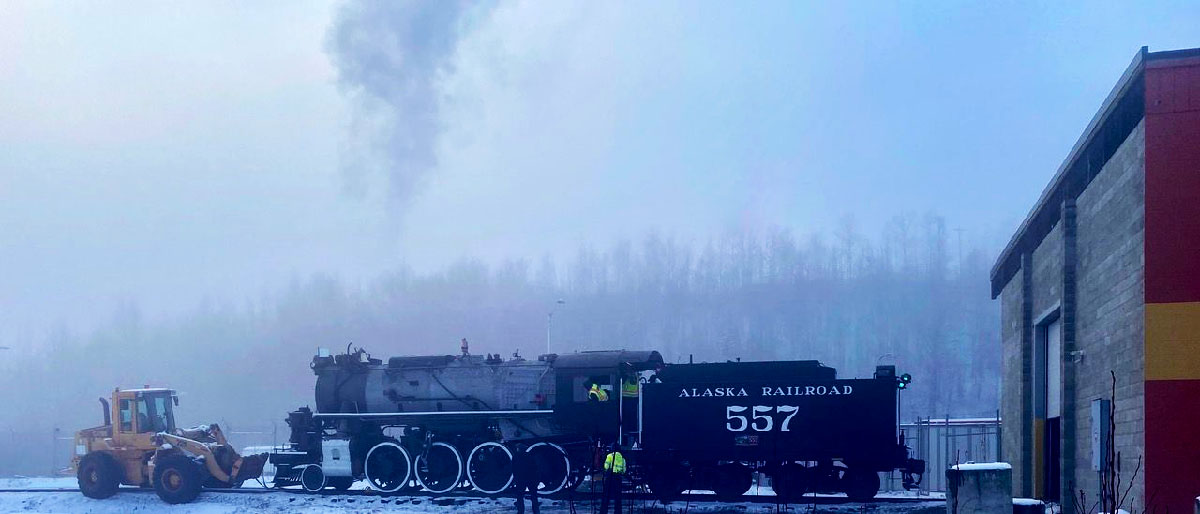 Steam locomotive outside shop on a foggy day for a test firing.