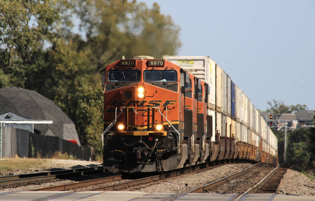 Double-stack train with three orange-fronted locomotives