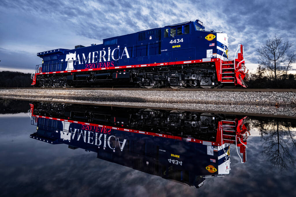 Red, white, and blue locomotive with large "America 250 lettering" and image of Liberty Bell