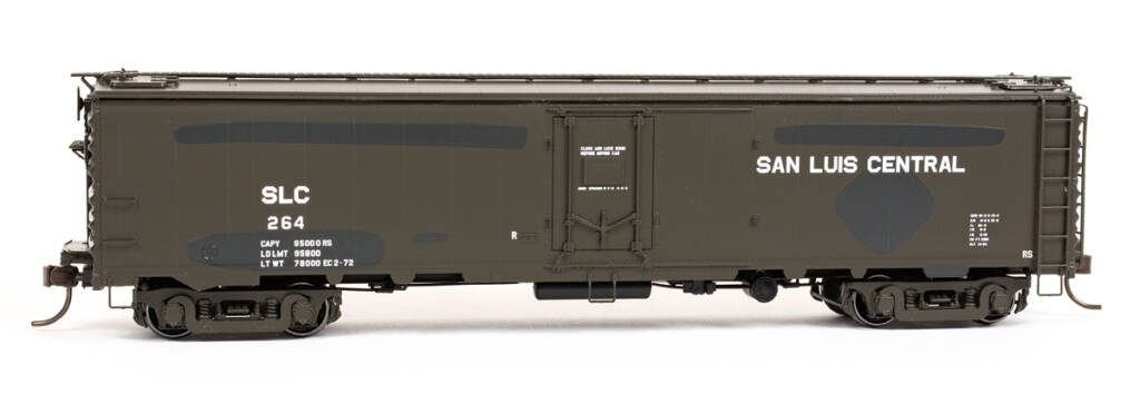 Color photo of HO scale REA steel express reefer painted weathered green with fresh dark green patches and white graphics on white background. 