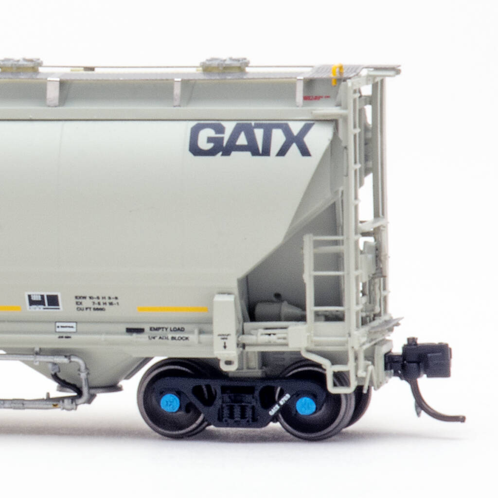 Color photo showing B end details on N scale covered hopper painted gray with black and yellow graphics on white background.