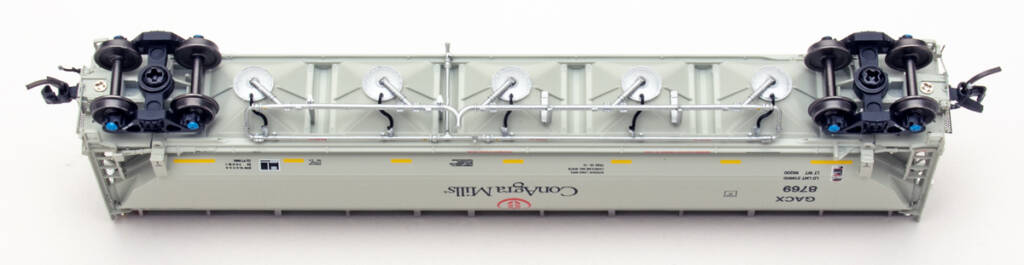 Color photo showing underbody details on N scale covered hopper painted gray with black, red, and yellow graphics on white background.