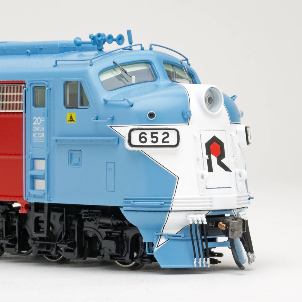 Color photo showing nose of HO scale six-axle cab unit painted red, white, and blue with star on nose on white background.