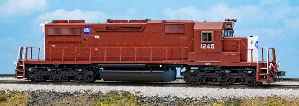 Color photo of HO scale EMD six-axle hood unit painted dark brown and white with blue and white graphics on scenicked base with a sky blue background. 