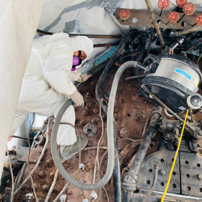 Man in a hazmat suit working in the cab of a steam locomotive. Restored American Freedom Train No. 1 to be unveiled.