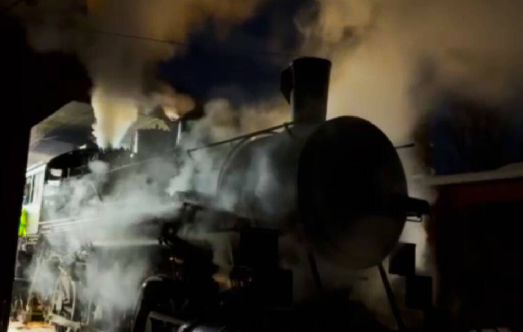 Steam locomotive surrounded by steam.