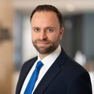 Head-and-shoulders shot of man in blue coat and tie. 