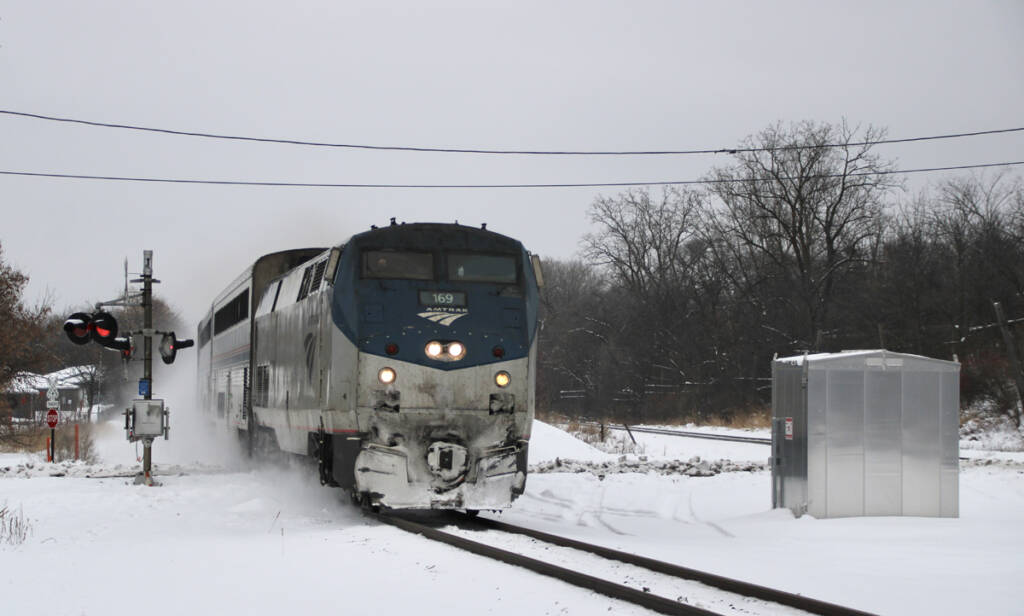 Passenger train at grade crossing in snow