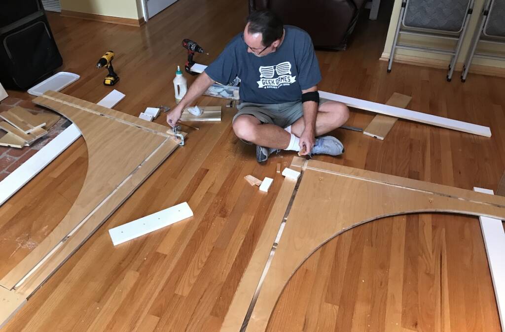 man next to wood pieces on the floor