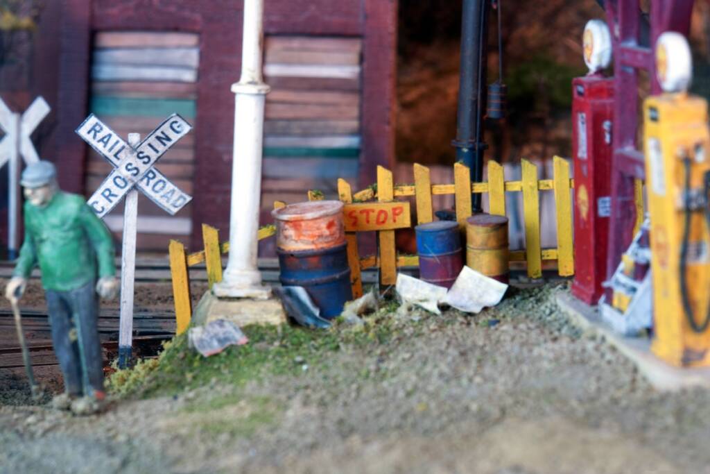  yellow model fence with figure and gas pumps