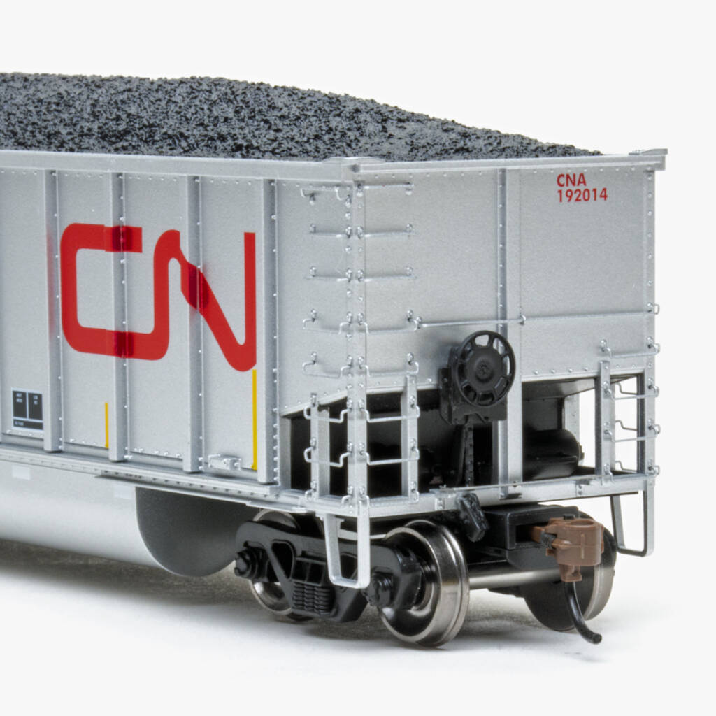 Color photo showing B end of HO scale bathtub gondola painted aluminum and red with red, yellow, black, and white graphics on white background.