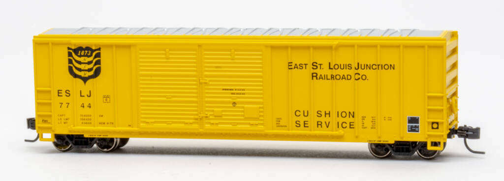 Color photo of N scale double-door boxcar with exterior posts painted yellow with black graphics on white background.