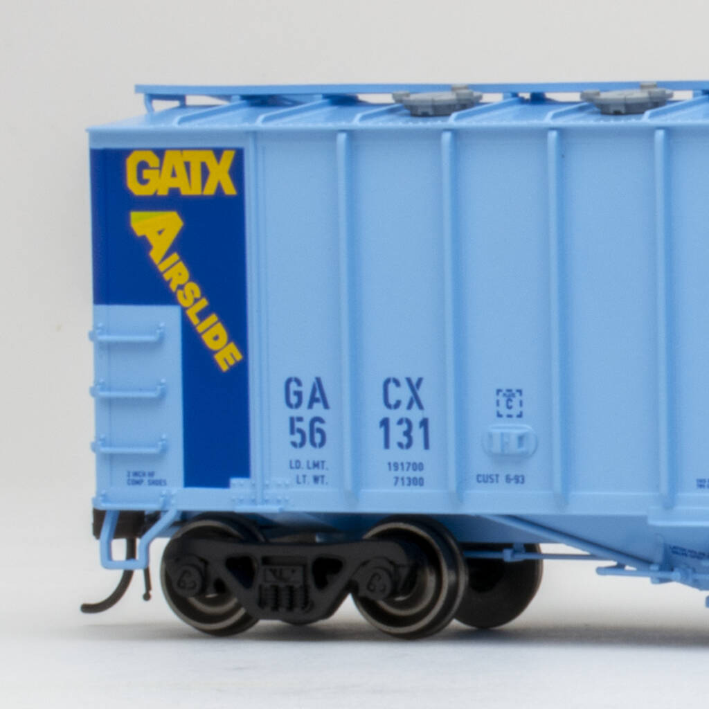 Color photo of showing portion of HO scale covered hopper painted two-tone blue with yellow, blue, black, and white graphics on white background.