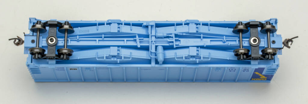Color photo showing underbody of HO scale covered hopper painted light blue on white background.