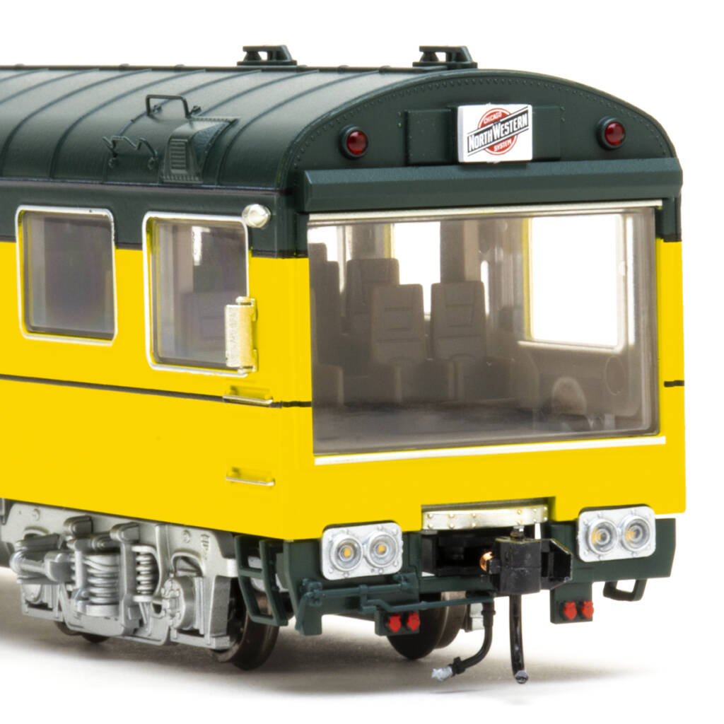 Color photo showing picture window end of HO scale theater car painted green and yellow with silver trucks.
