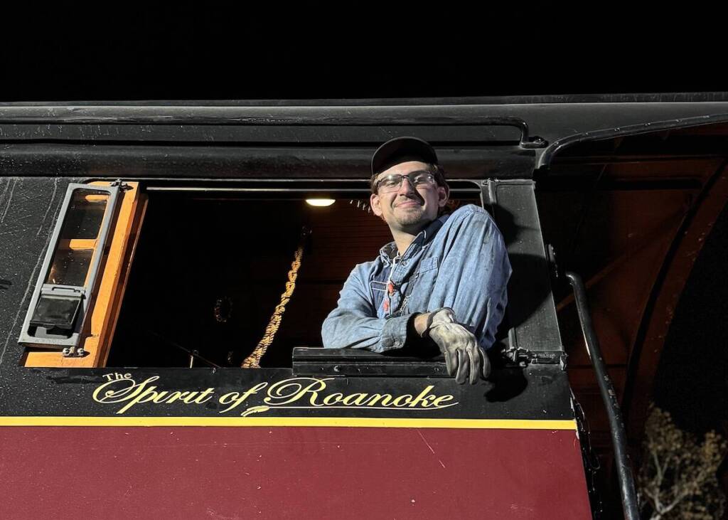 Young individual in the cab of a steam locomotive