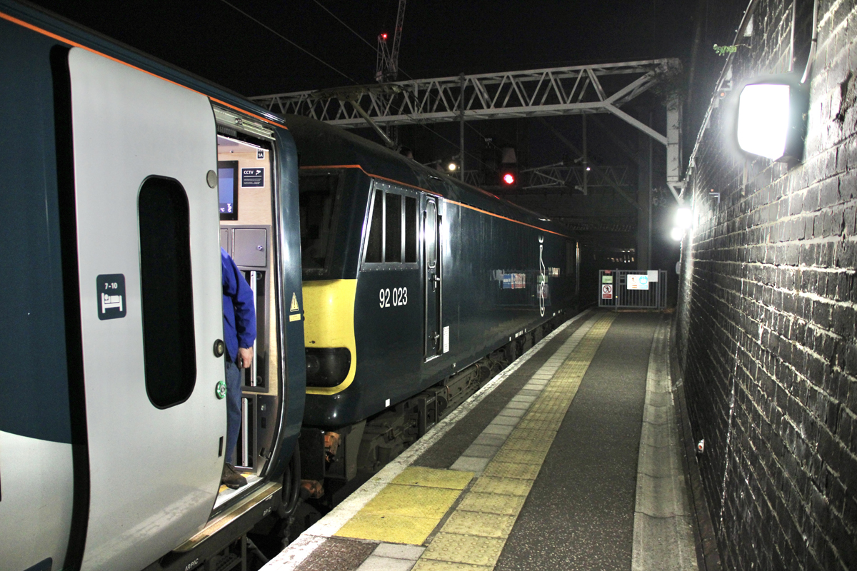 Locomotive and passenger car at station platform at night