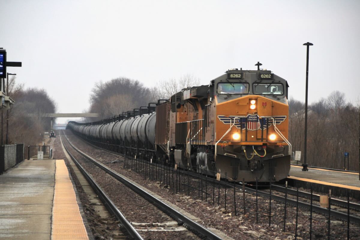 Unit train of tank cars at commuter rail station