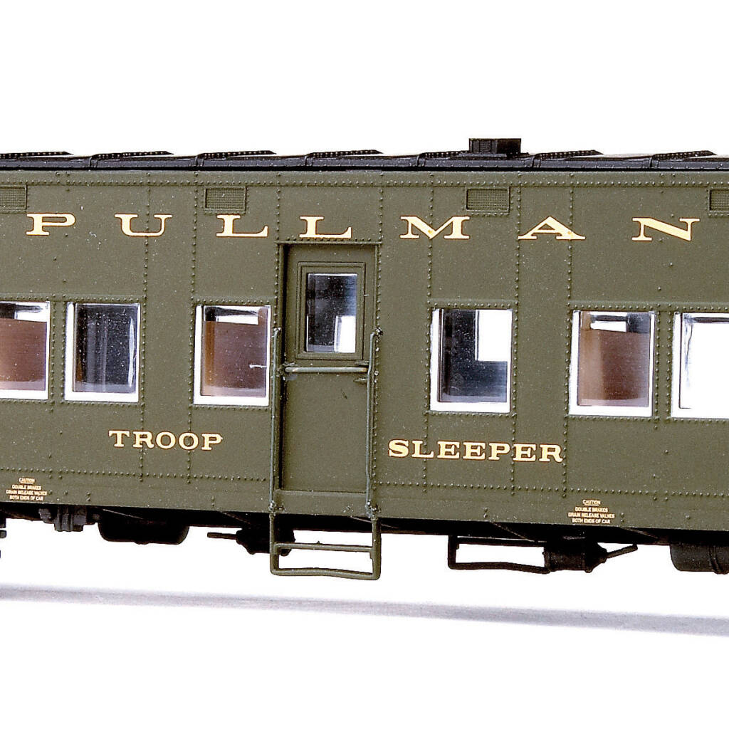 Color photo showing portion of Pullman HO scale troop sleeper painted dark green and black with gold lettering on white background.