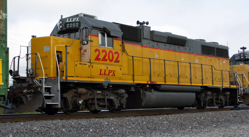 Color photo of EMD hood unit painted yellow and gray with red stripes and graphics.