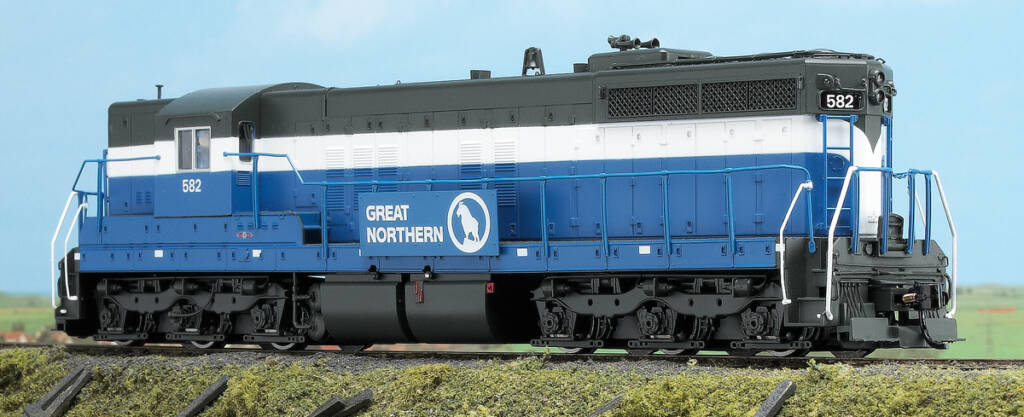Color photo of EMD hood unit painted blue, white, and gray on scenicked base with a sky blue backdrop.