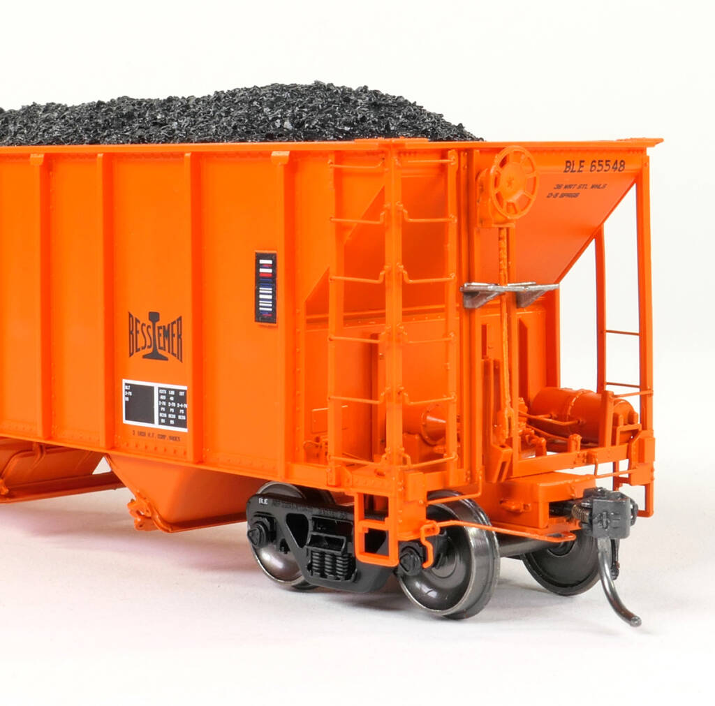 An orange model freight car end with a black coal load visible in the freight car