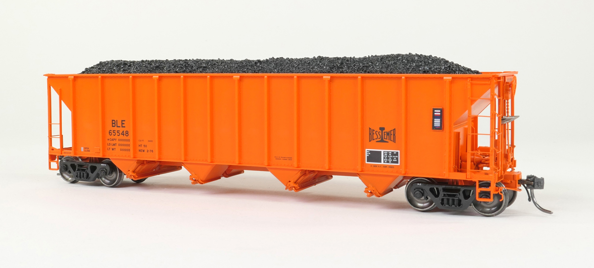 An orange model hopper car with black coal load