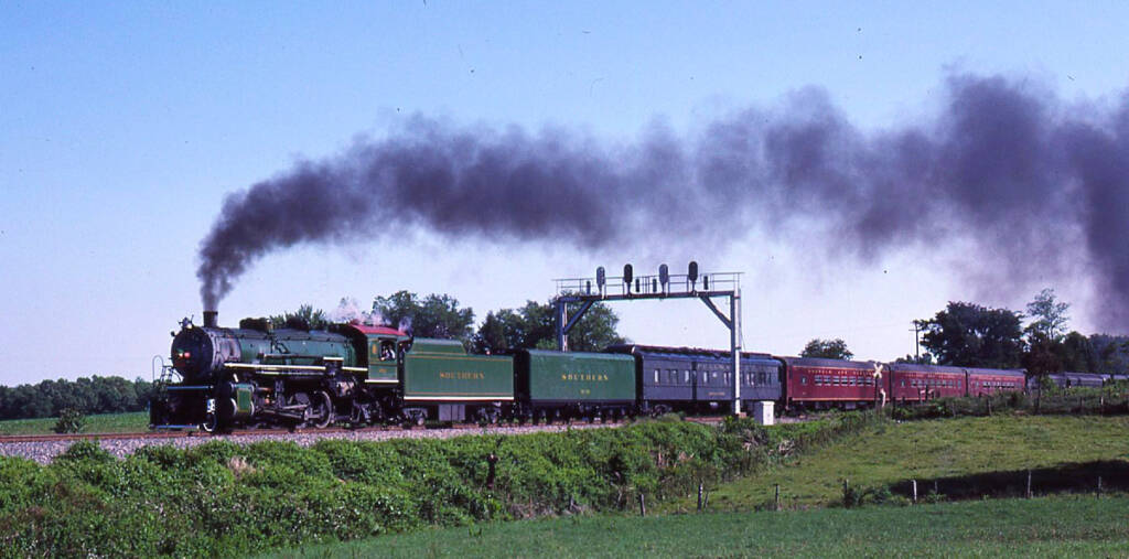 Green steam locomotive pulling a passenger excursion train. Southern Railway No. 4501 returns in classic green