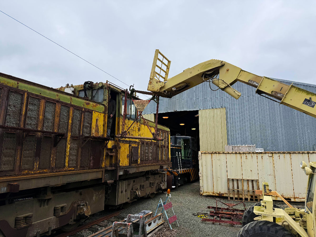 Forklift removes parts from an electric locomotive outside shop building. Western Railway Museum to restore Kennecott electric locomotive.