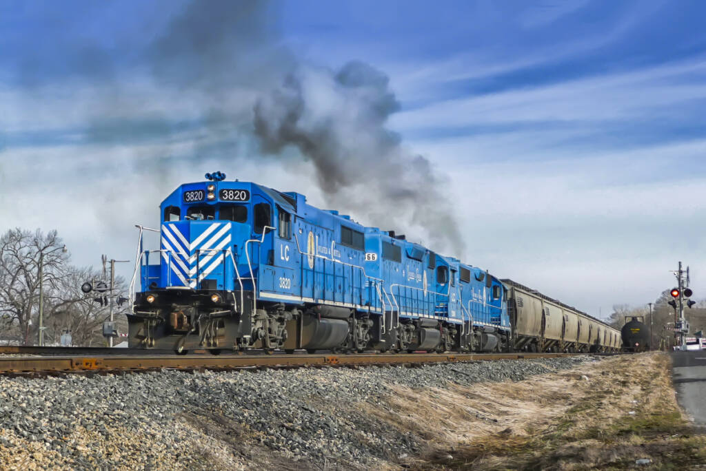 A blue locomotive leads a freight train